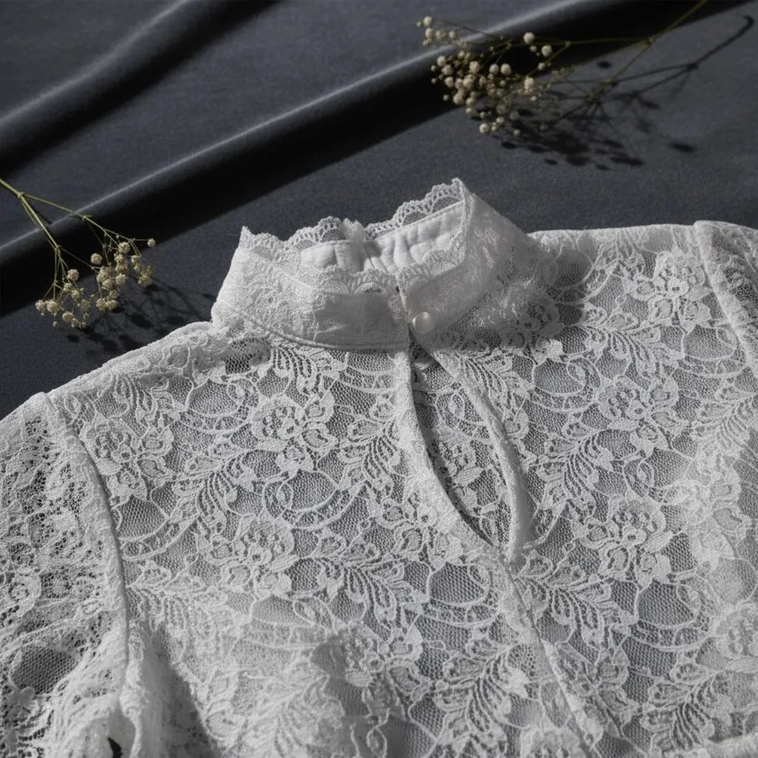 Close-up detail of white floral lace fabric on a dark background