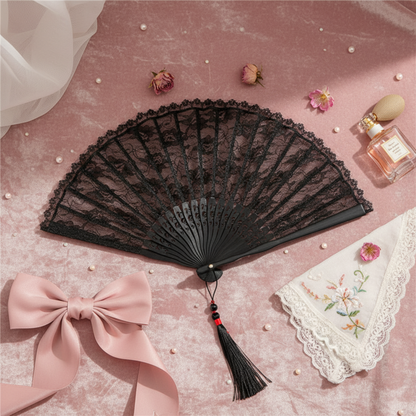 Black lace fan with pink bow on white fabric
