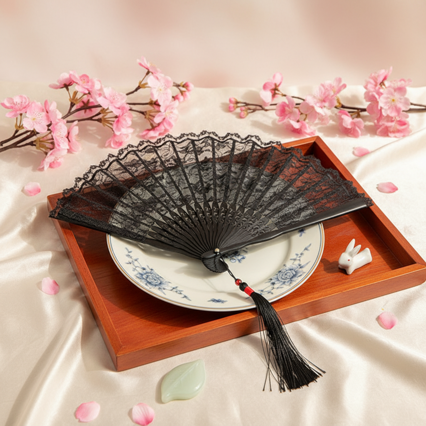 Black lace fan on wood tray with pink flowers