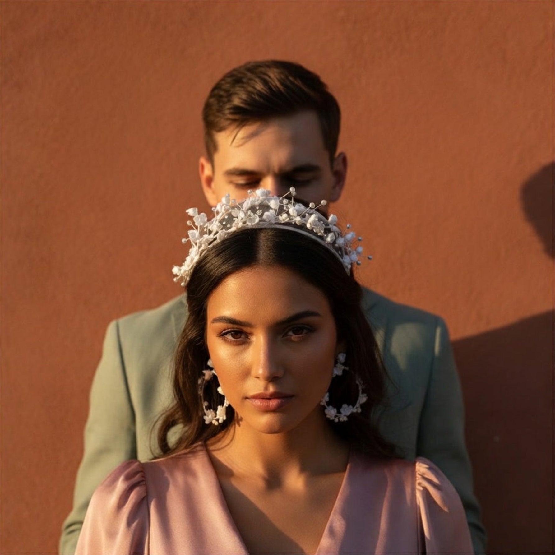 Couple with woman wearing flower crown headband, terracotta background