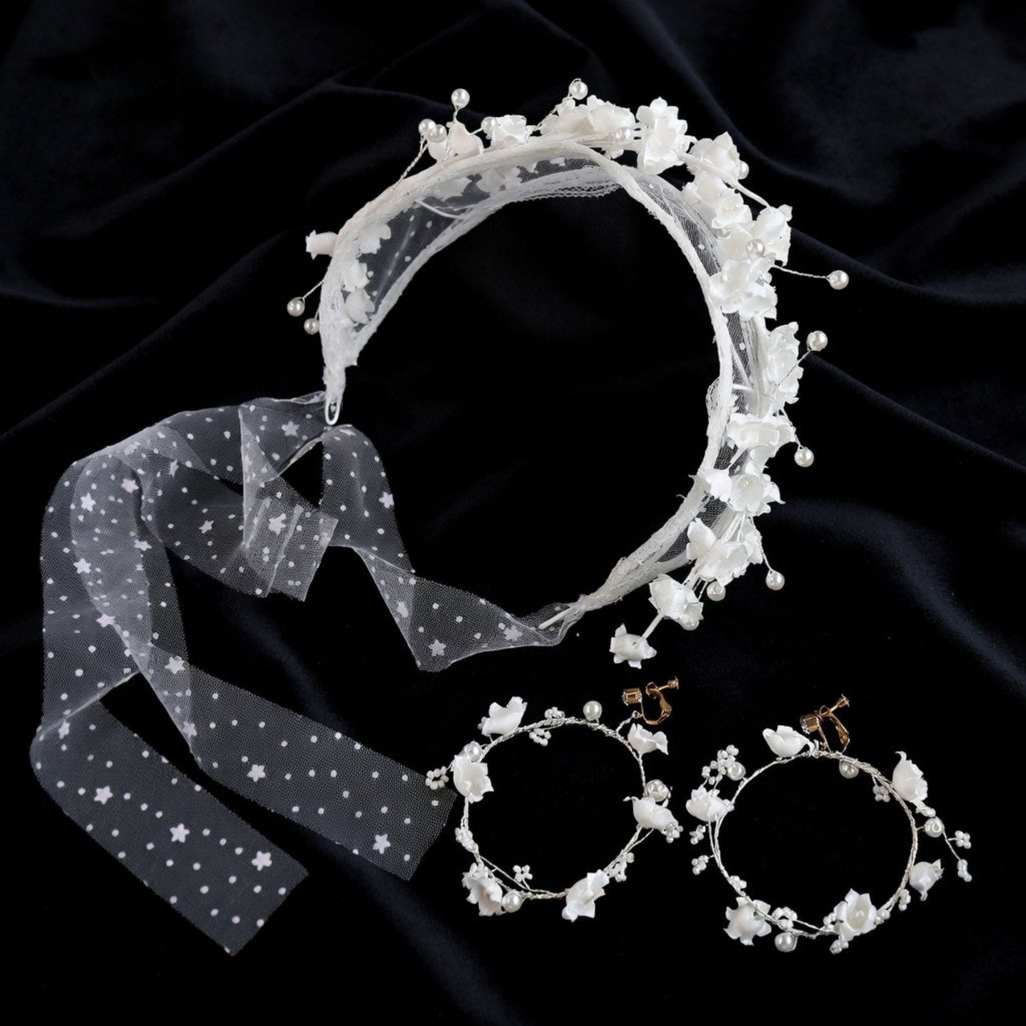 Flower crown headband and earrings flat lay on navy velvet