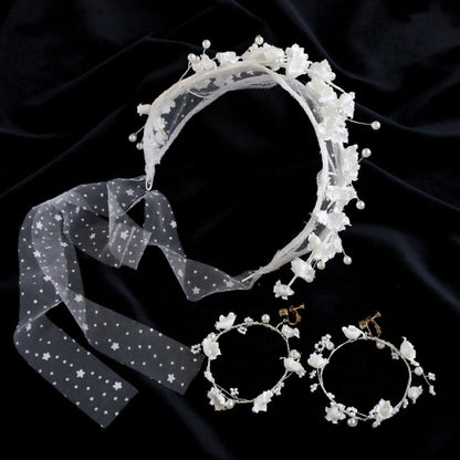 Flower crown headband and earrings flat lay on navy velvet