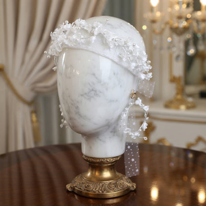 White flower crown headband on mannequin head with candles