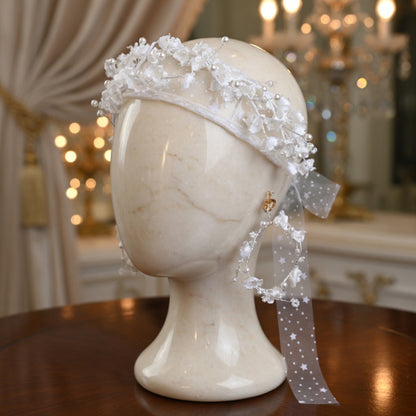 White flower crown bridal headband on mannequin head with ivory curtain