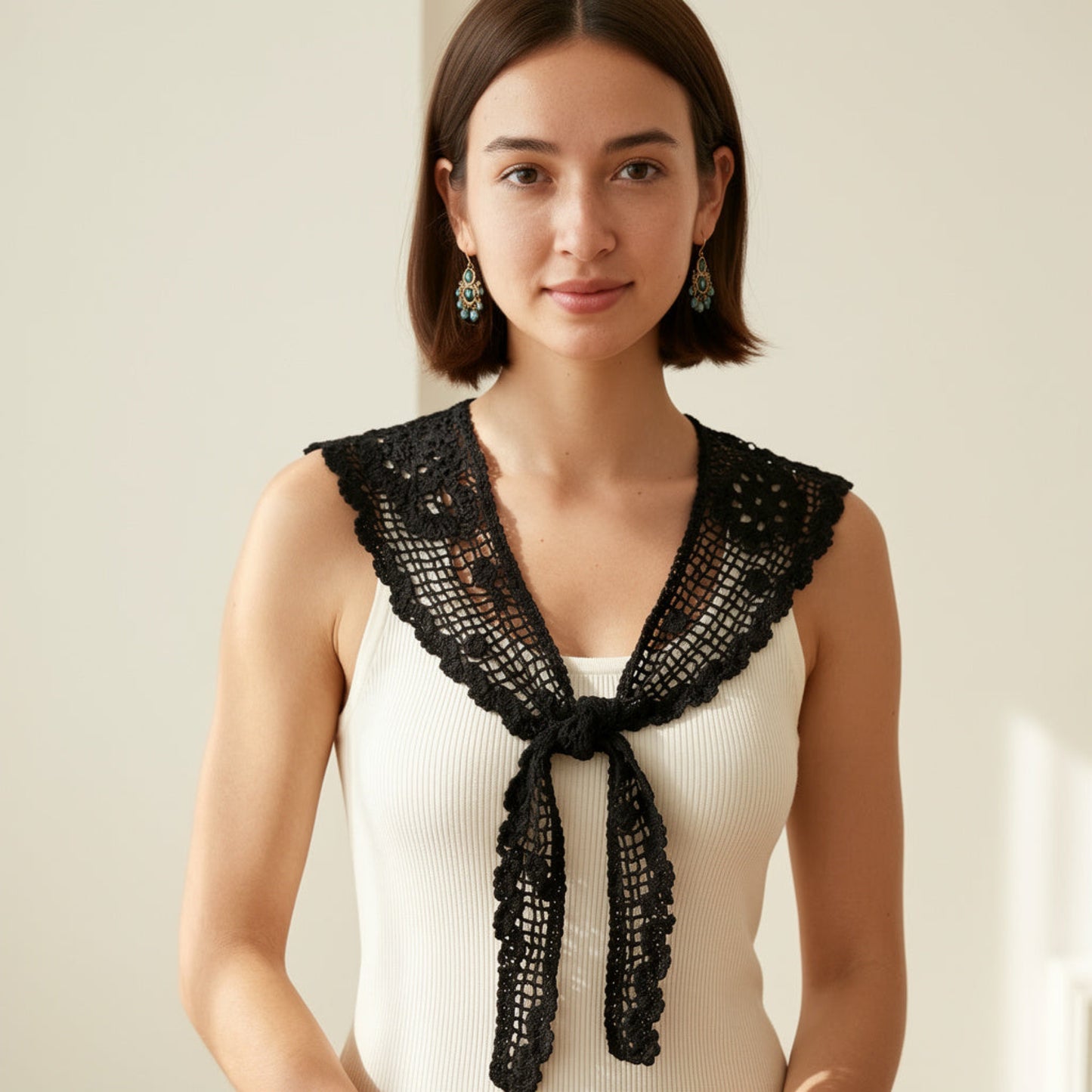 Woman wearing black crochet lace shawl collar over beige top