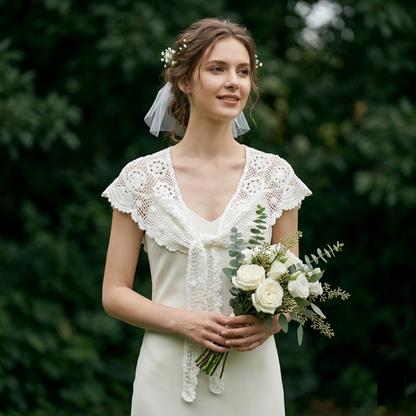 Bride wearing white crochet lace shawl with veil in garden