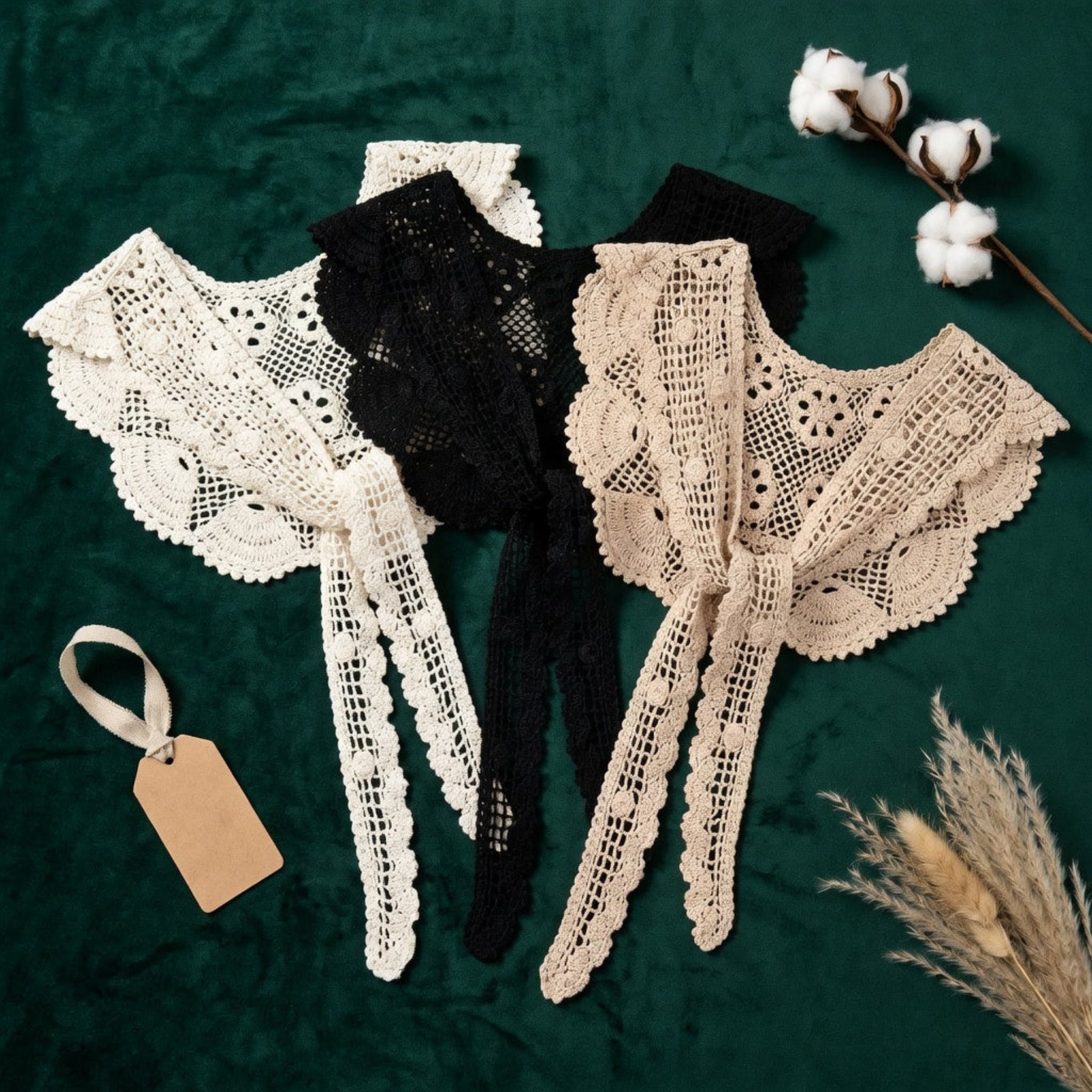 Apricot and black crochet lace shawls flat lay on dark green fabric