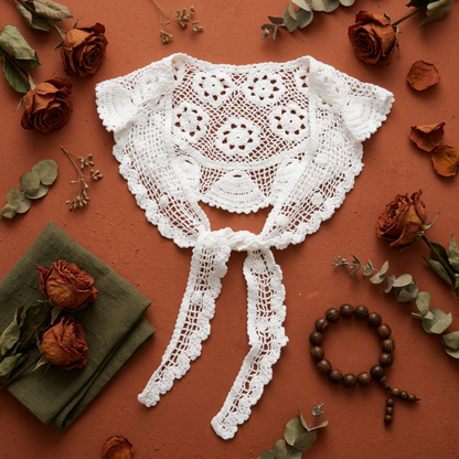 White crochet lace shawl flat lay on rust background with leaves