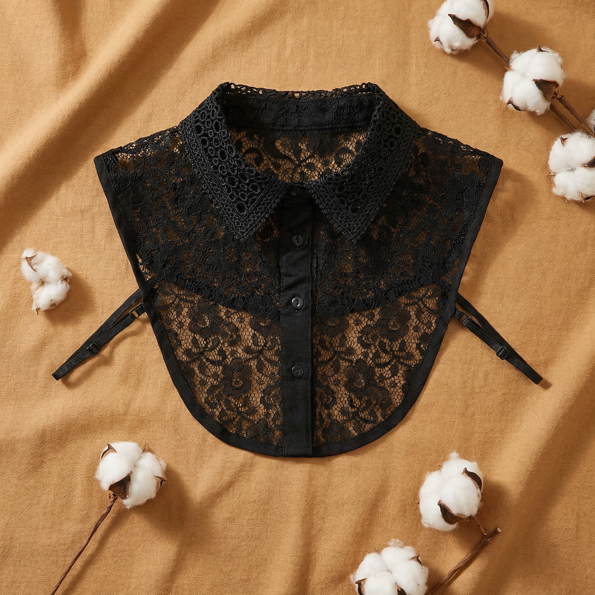 Black lace detachable collar flat lay on tan cotton fabric
