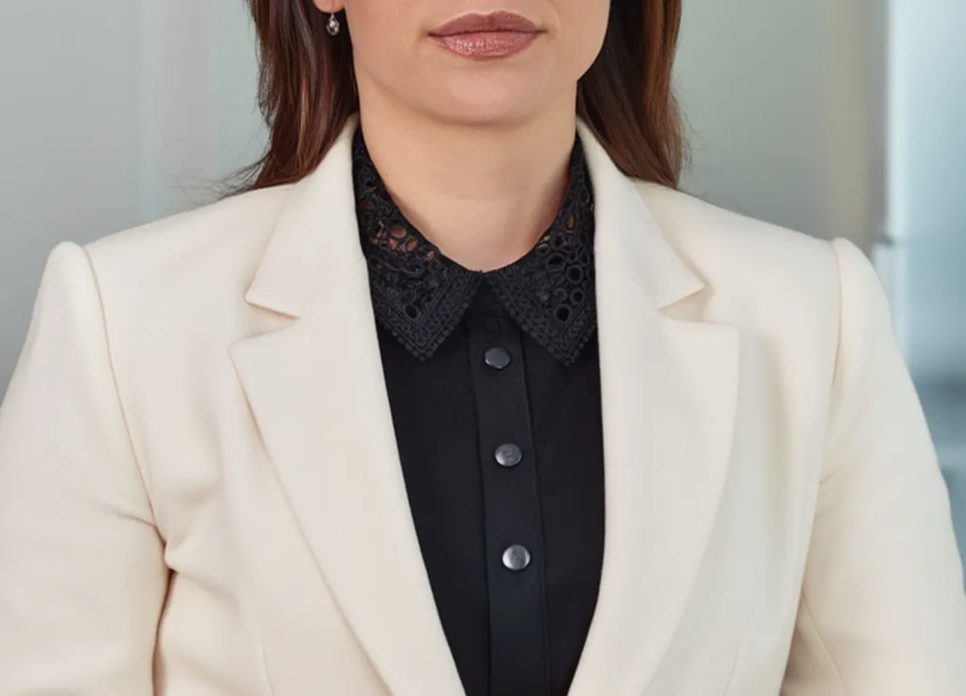 Woman wearing black lace collar over white blazer