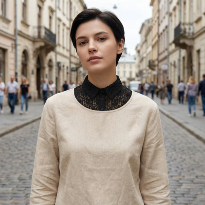 Woman wearing black lace collar over cream sweater on city street