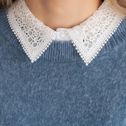 Close-up of white lace collar worn over denim shirt