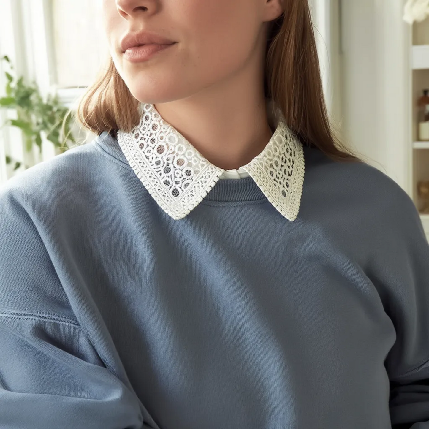 Close-up of white lace collar worn over gray sweater