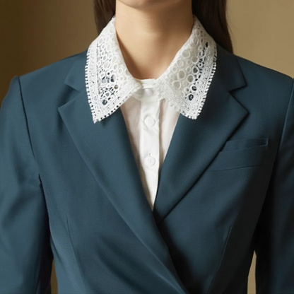 Close-up of white lace collar worn over teal blazer