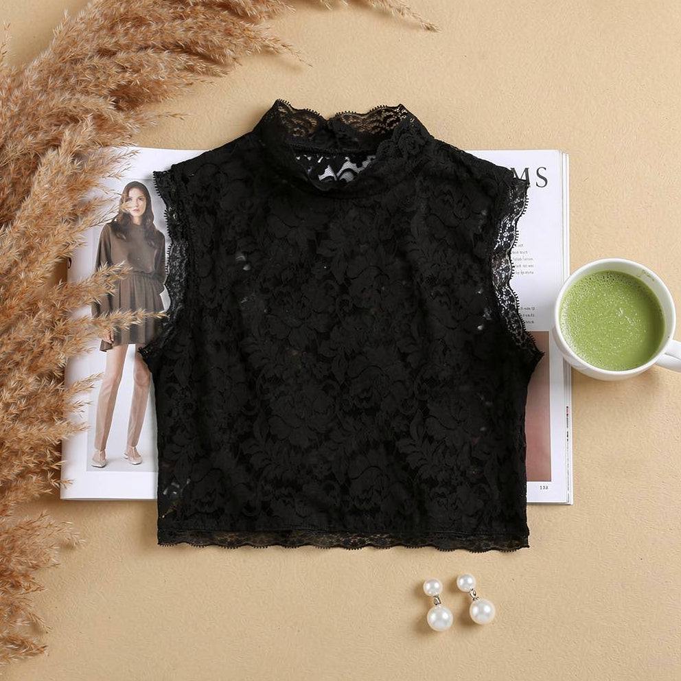Black floral lace crop top flat lay on desk