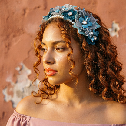 Woman with curly hair wearing blue floral lace headband