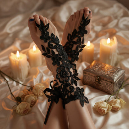 Black floral lace barefoot sandal worn on foot with candlelit bokeh