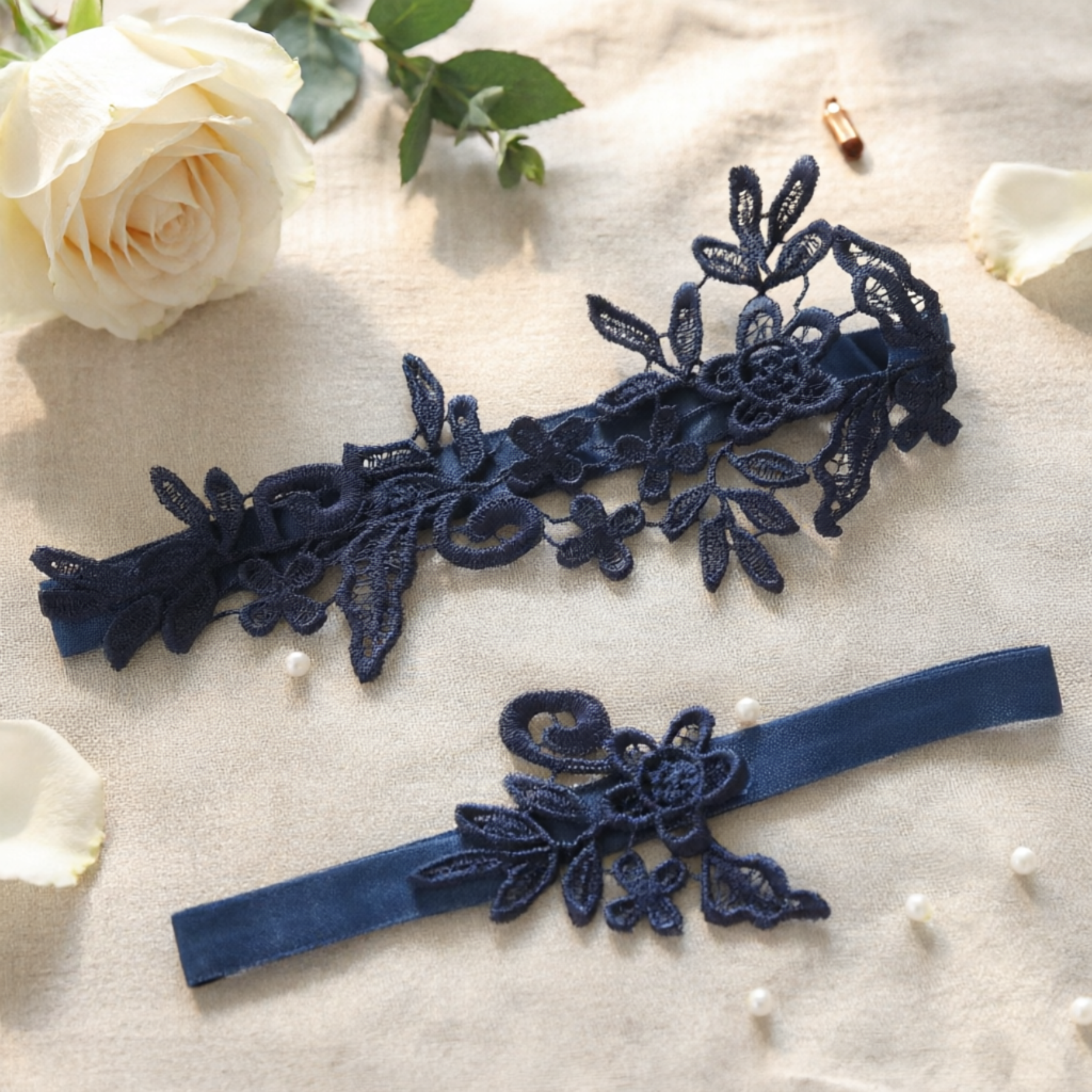 Navy blue lace bridal garter set flat lay on lace fabric