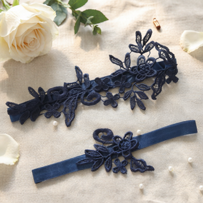 Navy blue lace bridal garter set flat lay on lace fabric