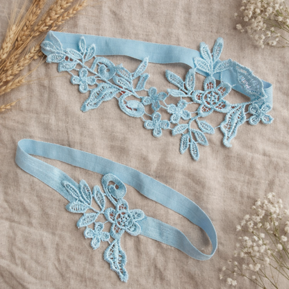 Sky blue lace bridal garter set flat lay on linen fabric