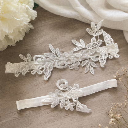 White lace bridal garter set flat lay on fabric