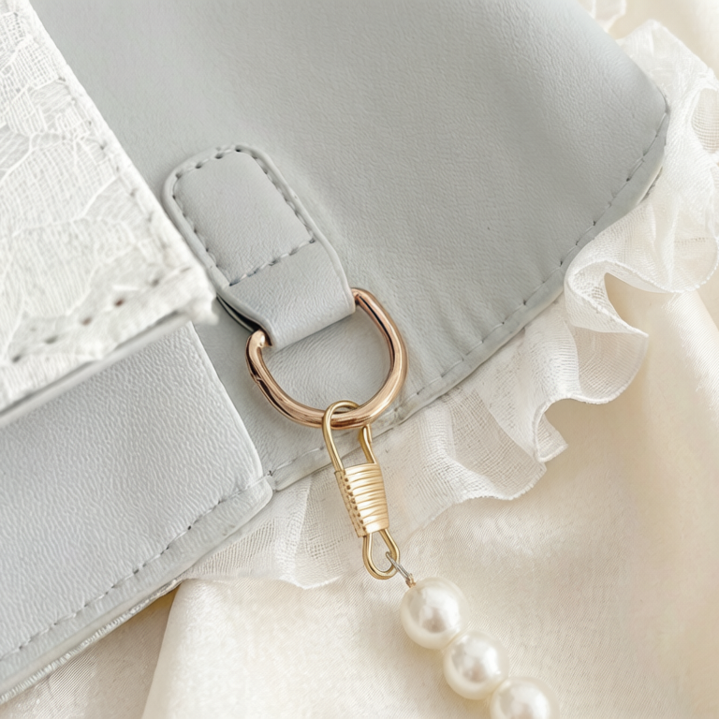 Close-up of white lace crossbody bag ring hardware and lace texture