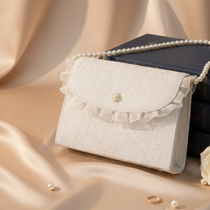 Close-up of white lace crossbody bag on ivory satin fabric