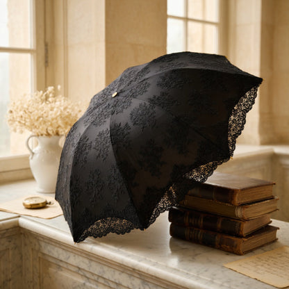 Black lace embroidery umbrella on window ledge with books