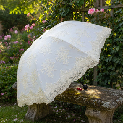 White lace embroidery umbrella in garden with roses