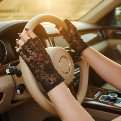 Woman driving wearing black lace fingerless gloves, touchscreen-compatible design