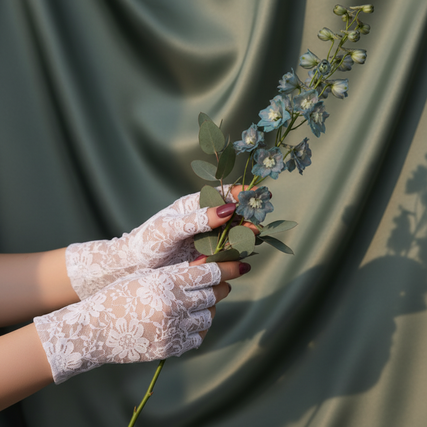 White lace fingerless glove holding eucalyptus sprig, bridal lace glove detail