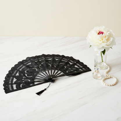 Black lace hand fan flat lay with white vase