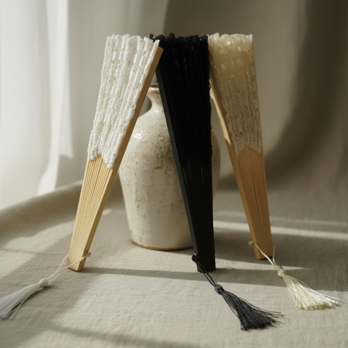 Black and white lace hand fans standing on fabric