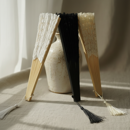 Black and white lace hand fans standing on fabric