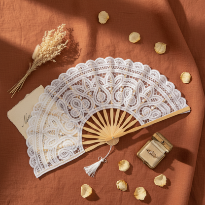 White lace hand fan flat lay with dried flowers