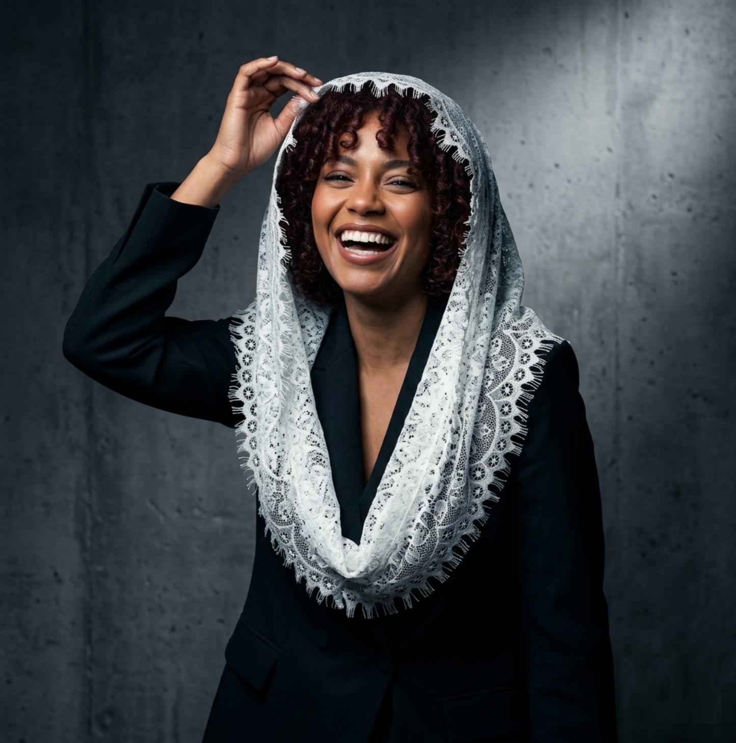 Woman laughing wearing ivory lace mantilla veil