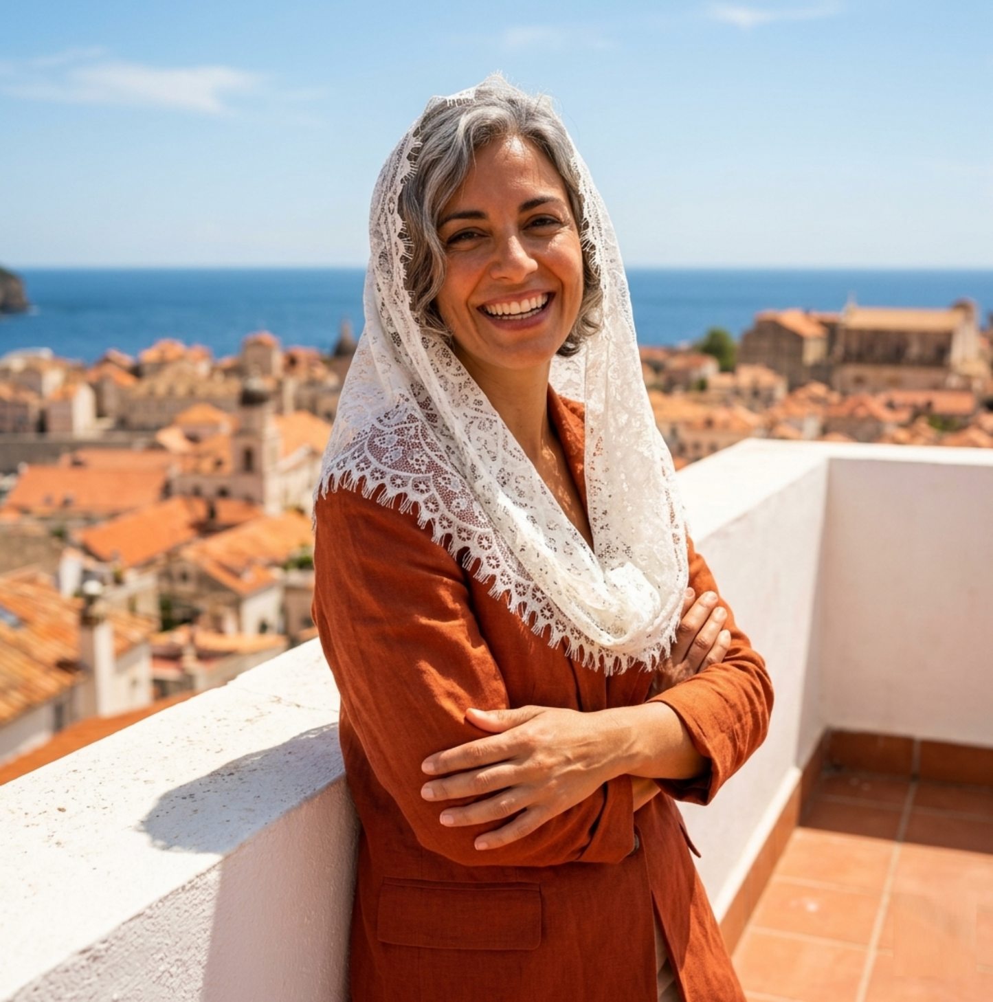 Woman wearing ivory lace mantilla veil on coastal rooftop