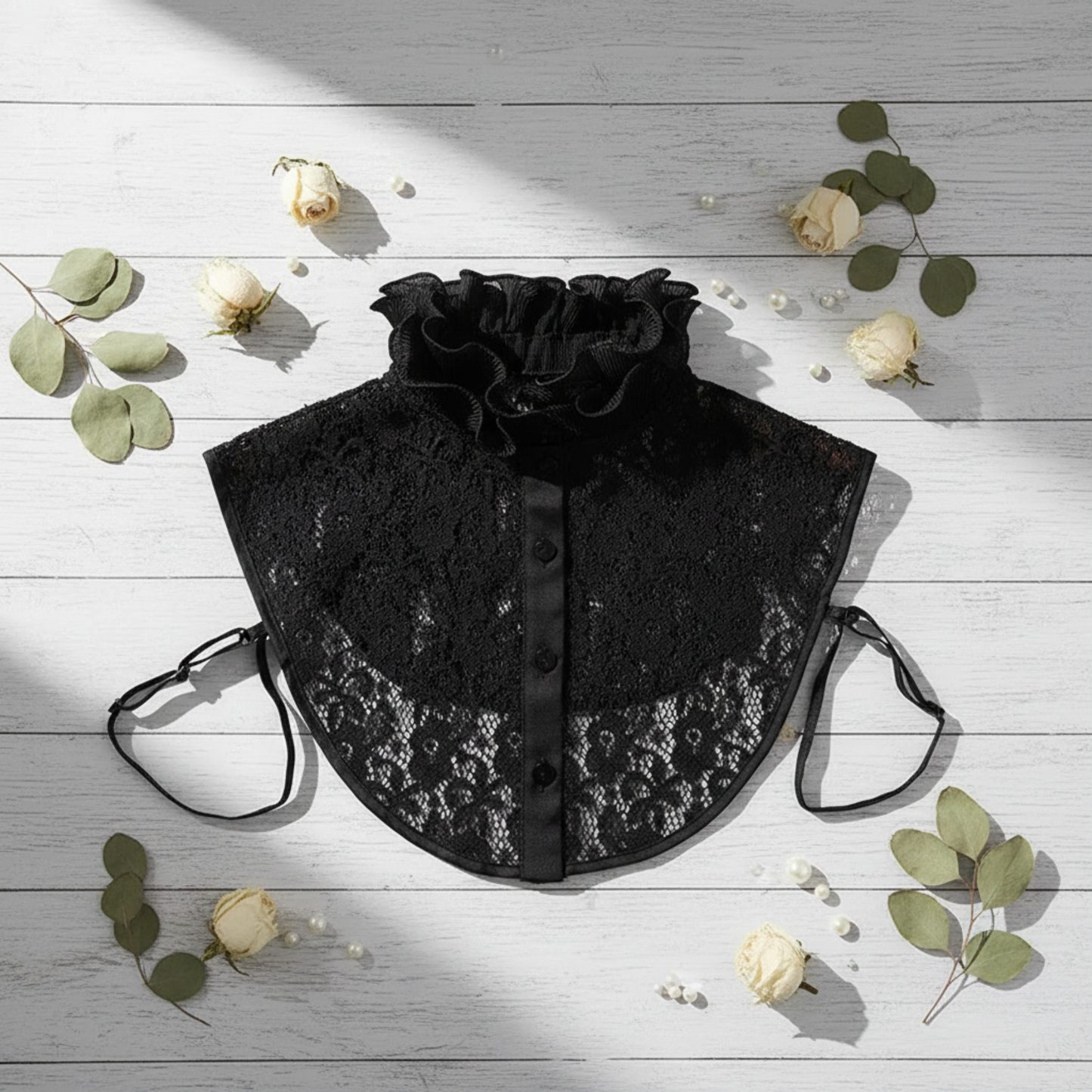 Black lace ruffle collar flat lay with eucalyptus sprig