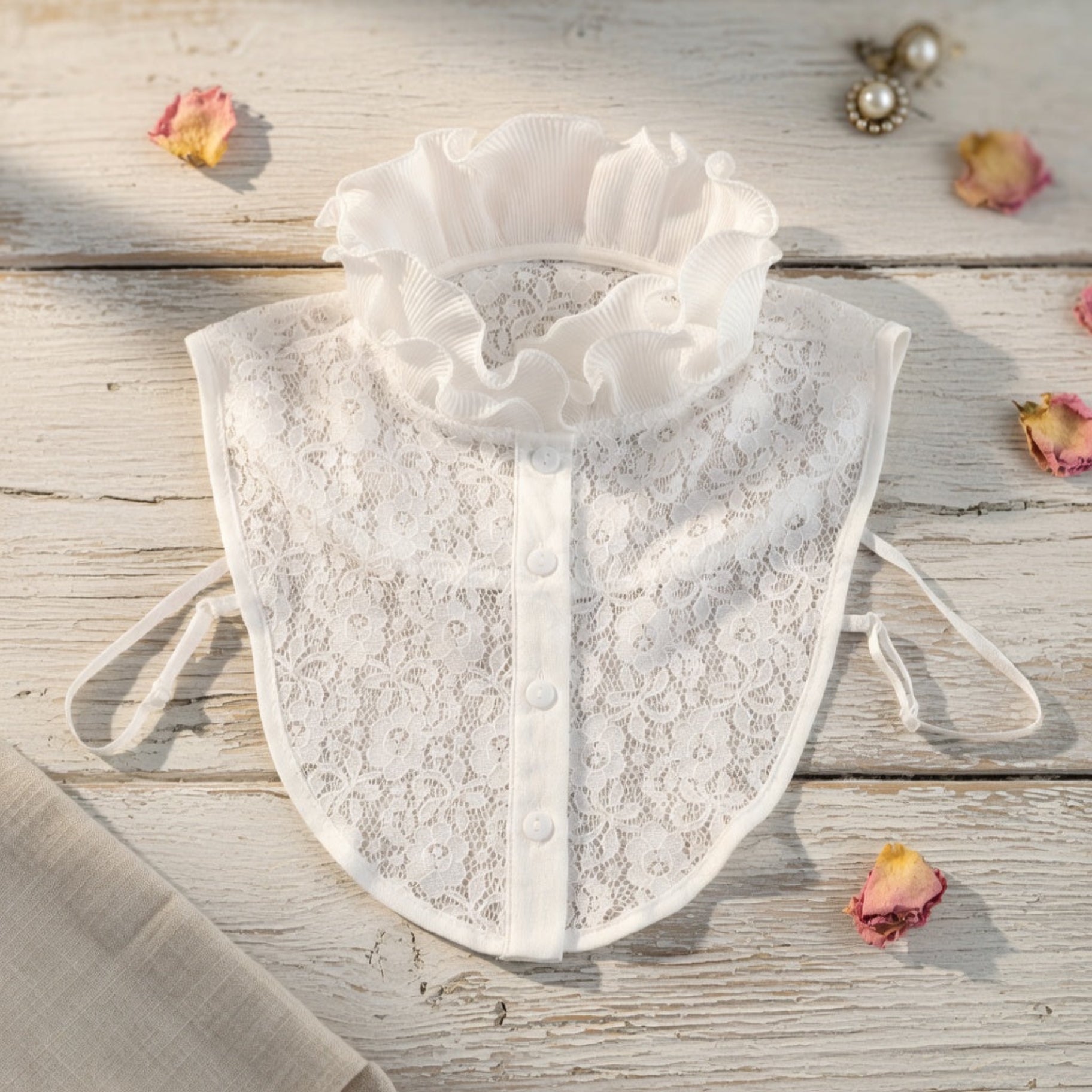 White lace ruffle collar flat lay on wood surface