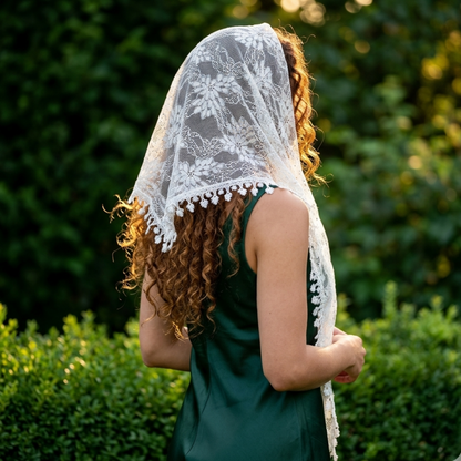 Woman with curly hair wearing black lace triangle scarf in garden