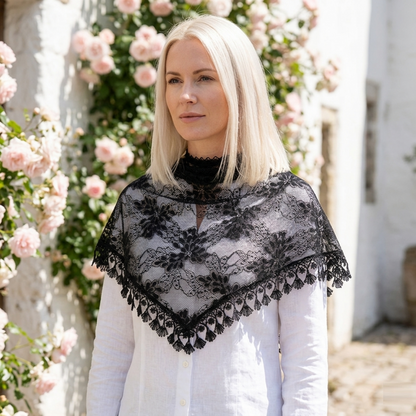 Woman wearing dusty rose lace triangle scarf over head in rose garden