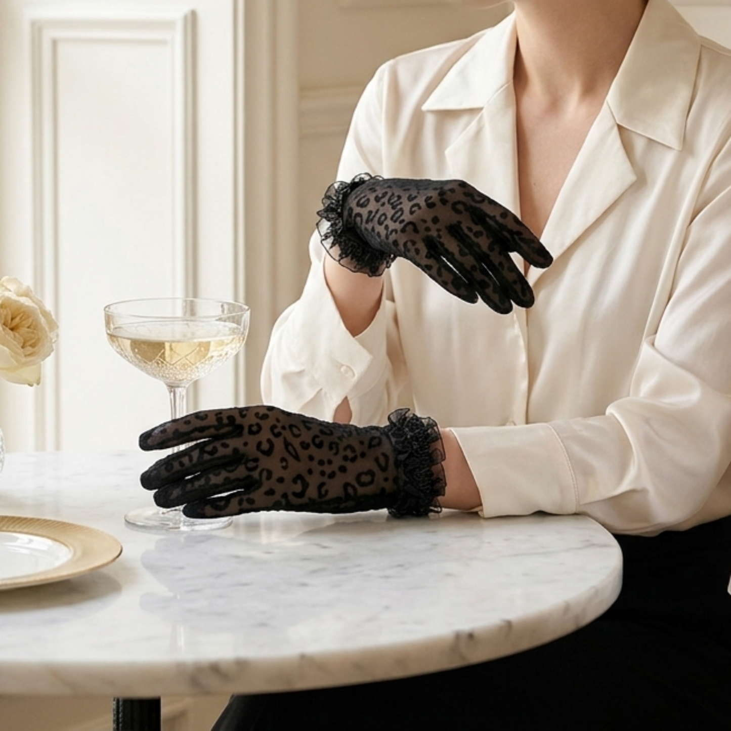 Woman at marble cafe table wearing black leopard print lace gloves
