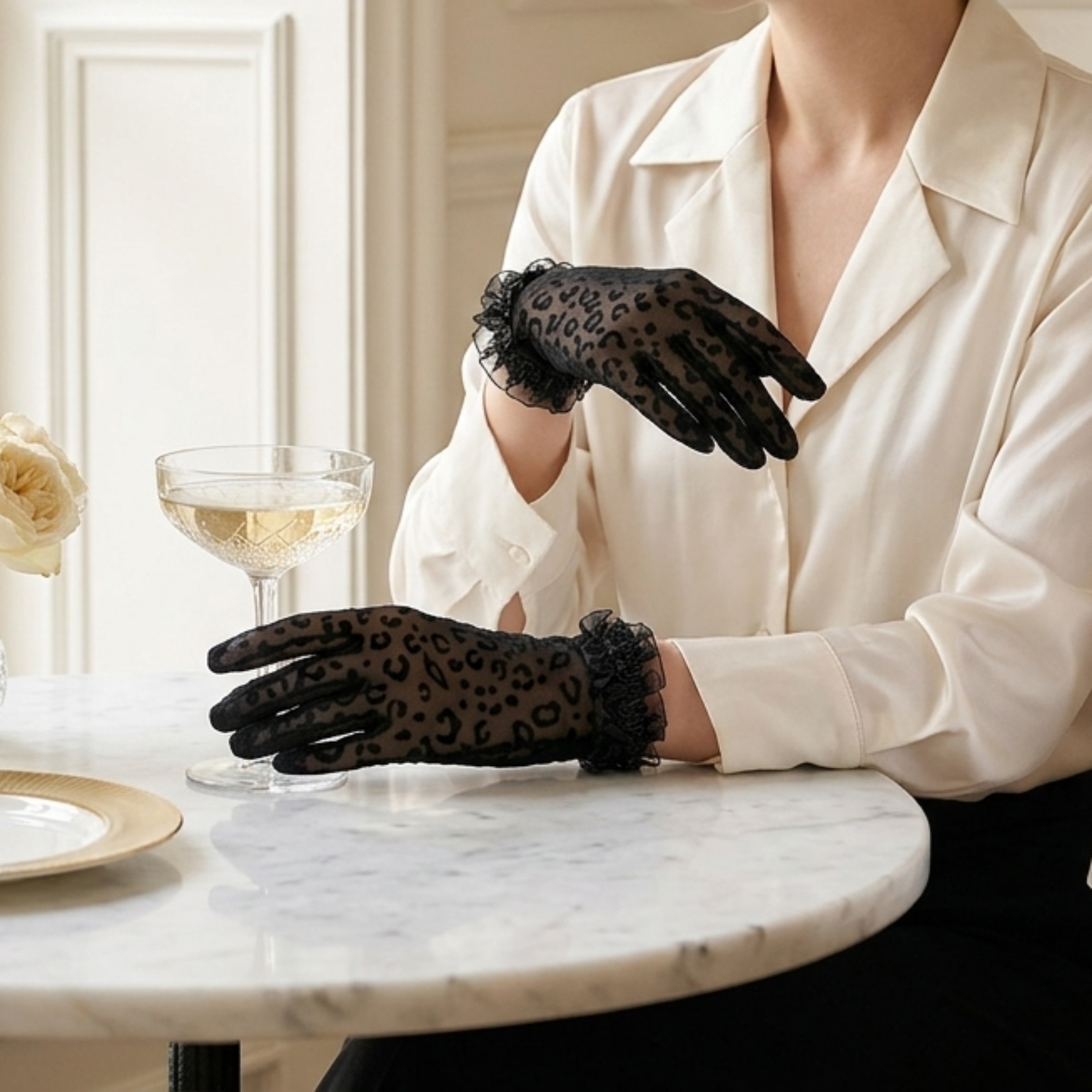 Woman at marble cafe table wearing black leopard print lace gloves