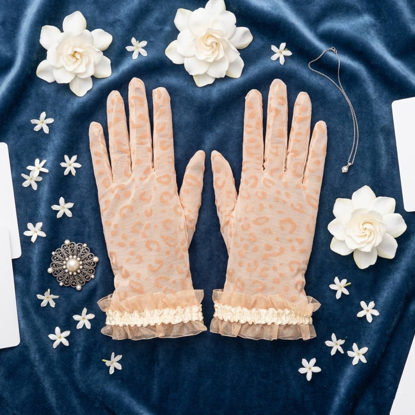 Nude leopard print lace mesh gloves flat lay on blue velvet with flowers