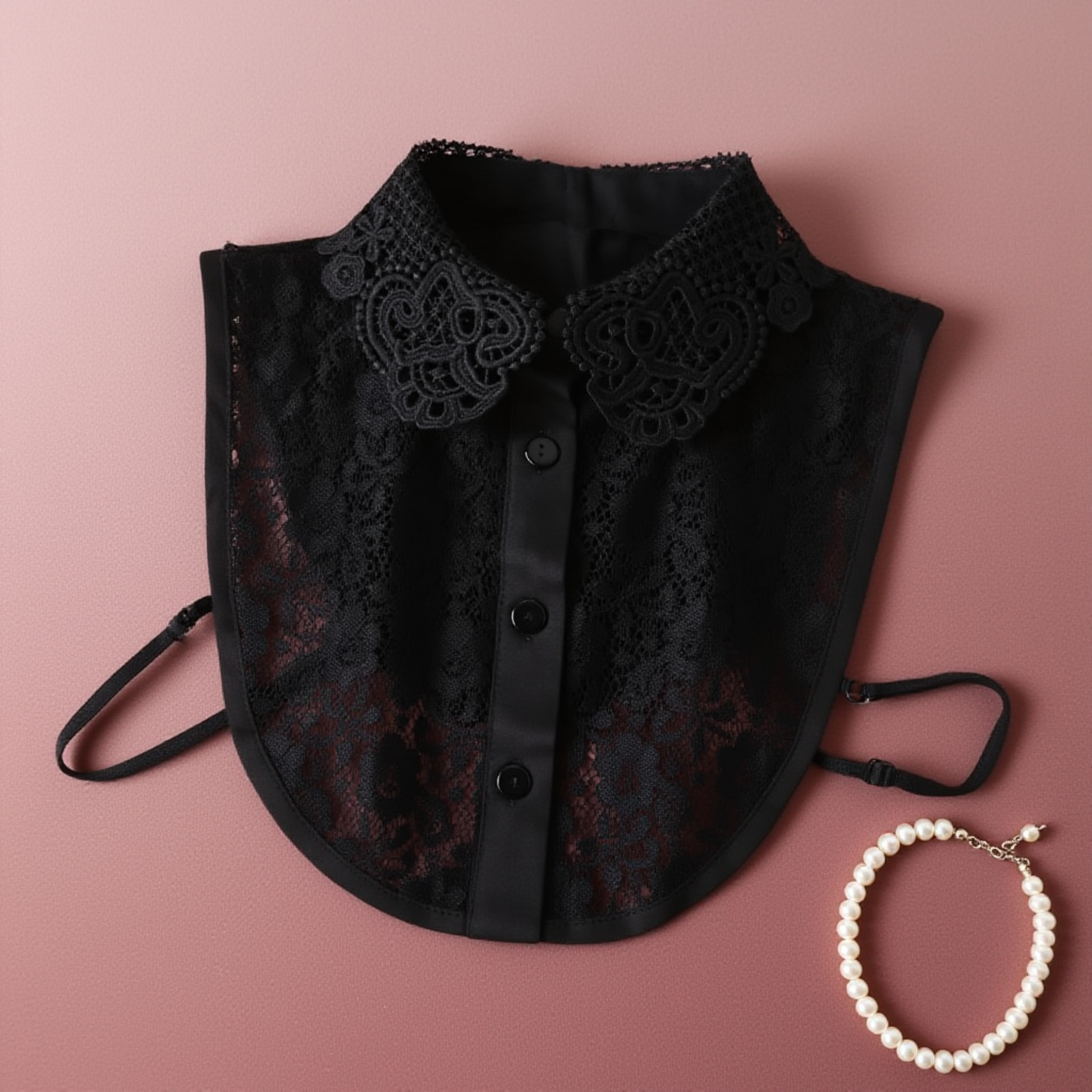 Black lace Peter Pan collar flat lay on pink fabric with pearls