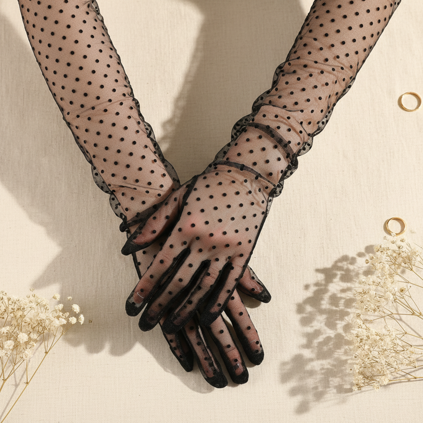 Close-up polka dot lace gloves with clasped hands on ivory background