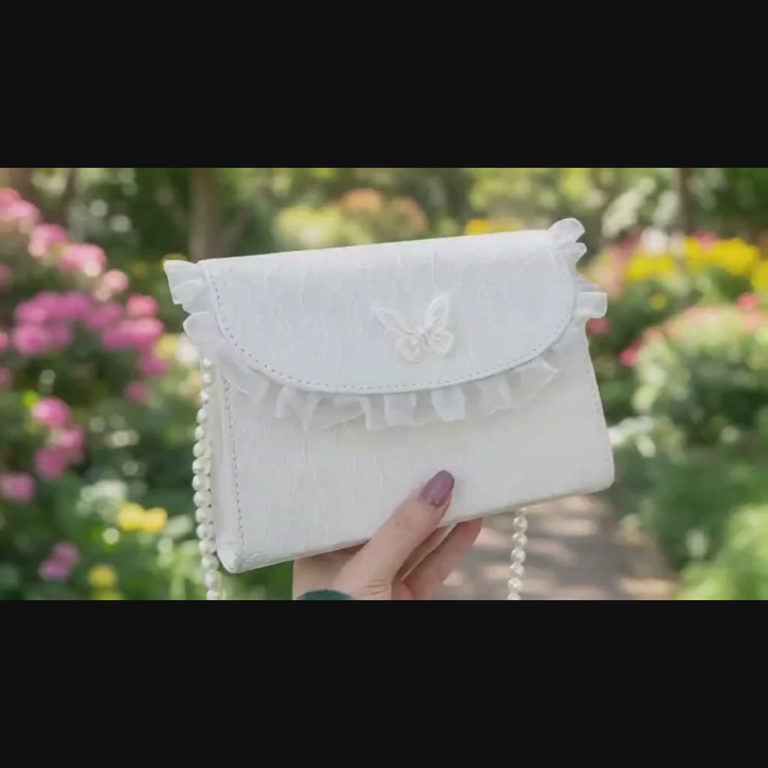 Video of white lace crossbody bag with pearl chain strap