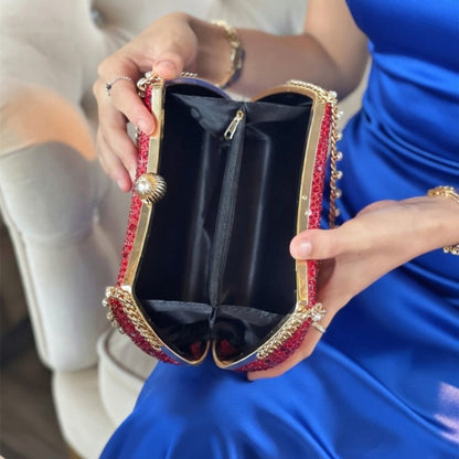 Woman in blue dress showing interior of gold rhinestone clutch