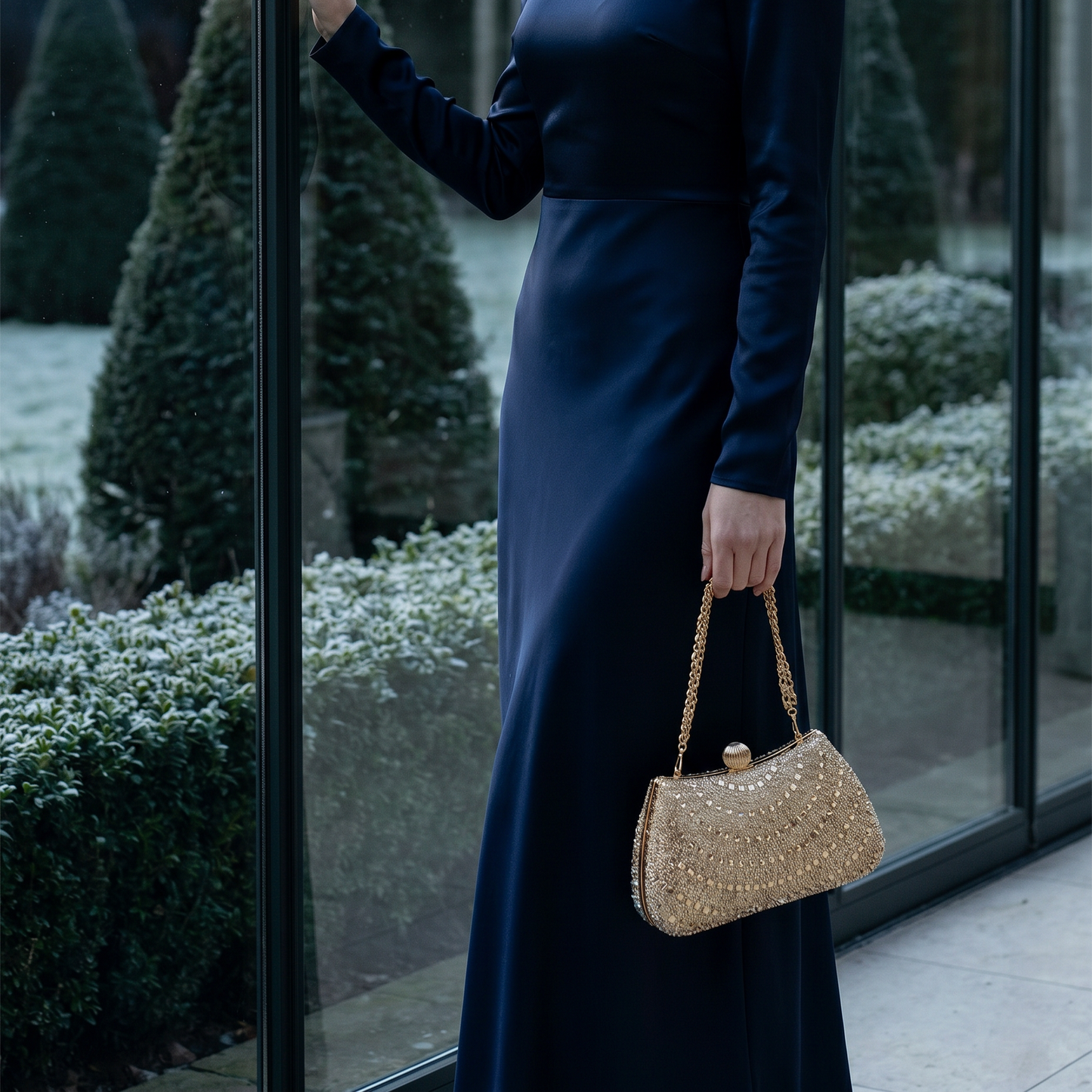 Woman carrying red rhinestone crystal clutch on garden path