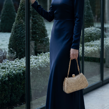 Woman carrying red rhinestone crystal clutch on garden path